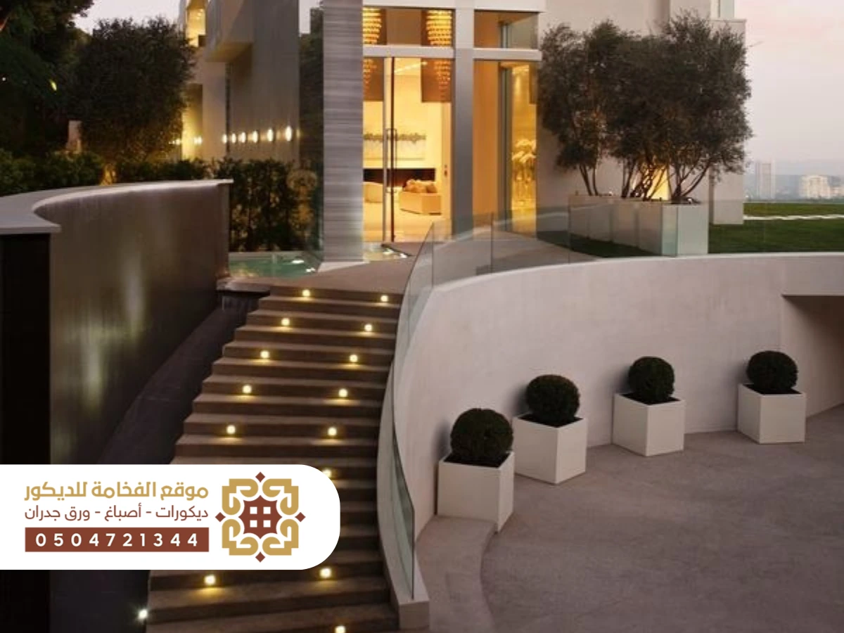 مدخل خارجي لمنزل مع درج واسع وأنيق يوصَل إلى الباب الأمامي، بتصميم معماري حديث وألوان متناسقة تعكس جمالية الواجهة.