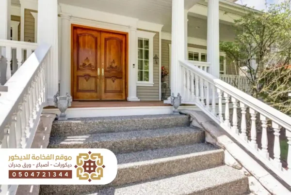 مدخل خارجي لمنزل مزود بدرج أنيق يؤدي إلى الباب الرئيسي مع تصميم معماري حديث.