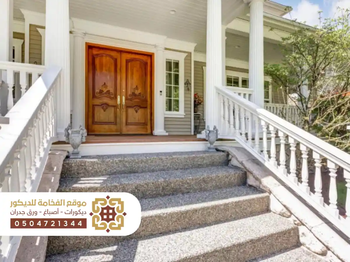 مدخل خارجي لمنزل مزود بدرج أنيق يؤدي إلى الباب الرئيسي مع تصميم معماري حديث.